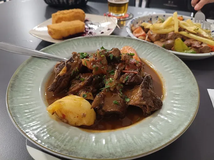 Carne en salsa con papa arrugada, en plato hondo