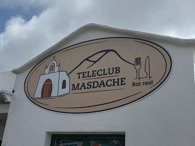 Rótulo oval del Teleclub Masdache sobre la fachada blanca