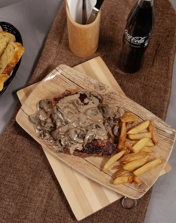 Solomillo con salsa de champiñones y papas, en la terraza de noche